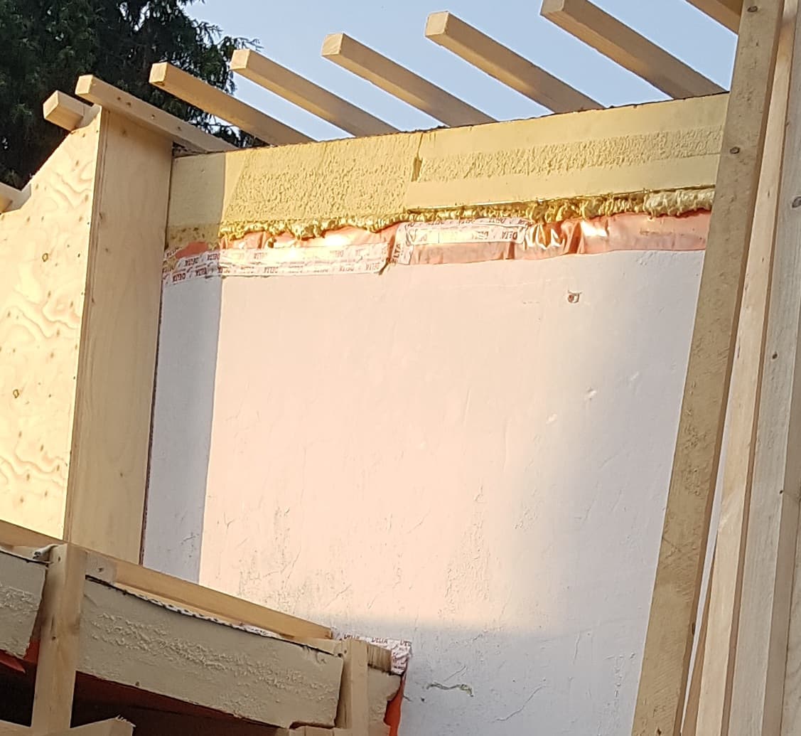 Detailansicht Aufsparren-Dämmung: Dämmung, Abdichtungsband und Holzkonstruktion an der Außenwand